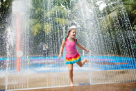 Los niños del círculo del arco iris del parque del espray de agua riegan el parque colorido del chapoteo del agua del patio